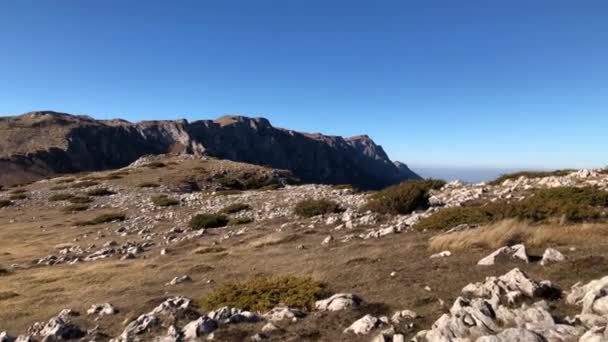 在一个阳光明媚的秋日 漫步在山顶的岩石地里 — 图库视频影像