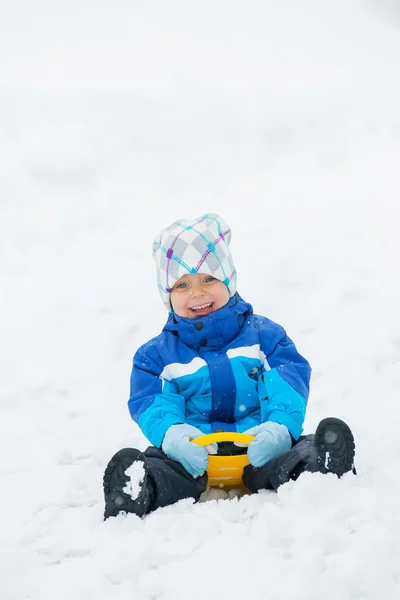 Pojken går för en enhet på en snö-lutning. — Stockfoto