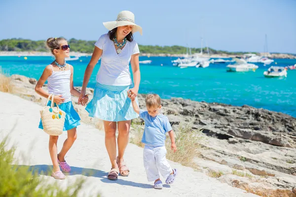 Family of three walking along tropical beach — Stock Photo, Image