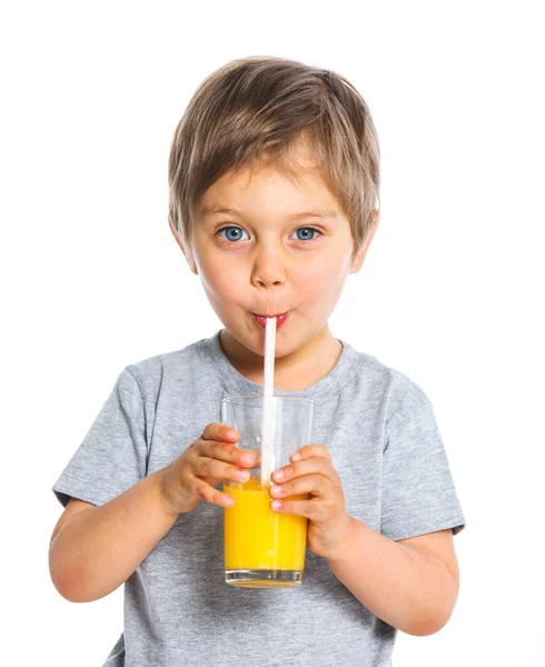 Porträtt av pojke dricka apelsinjuice Stockfoto