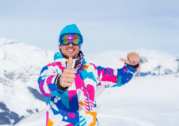 Jonge man met ski's en een skikleding — Stockfoto