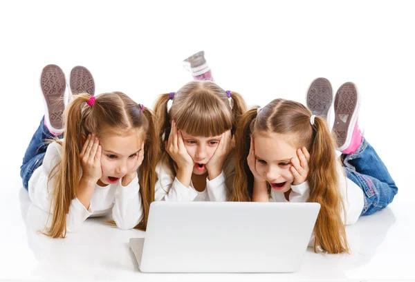 Tres chica atractiva usando un ordenador portátil — Foto de Stock