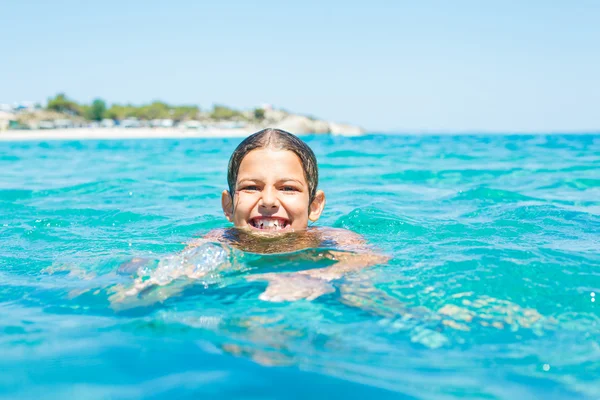 Ung flicka som leker i havet — Stockfoto