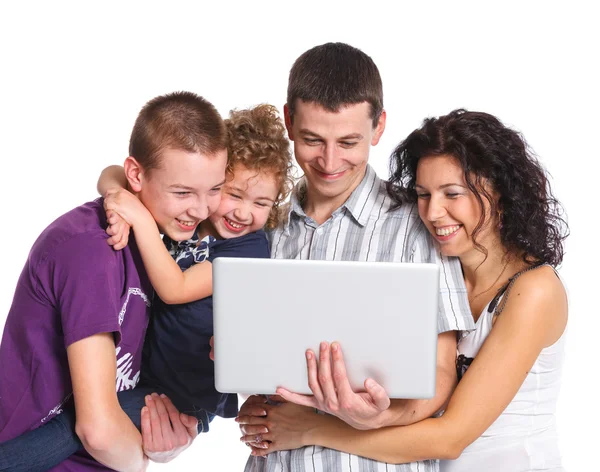 Junge Eltern mit Kindern am Laptop — Stockfoto