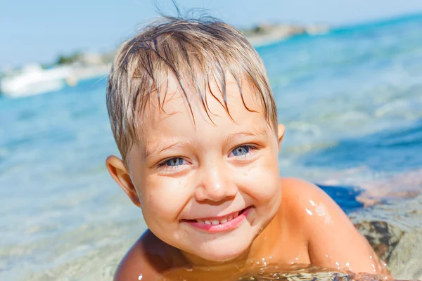 Rapaz bonito brincando no mar — Fotografia de Stock