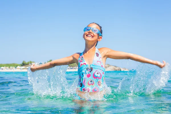 Jong meisje spelen in de zee — Stockfoto