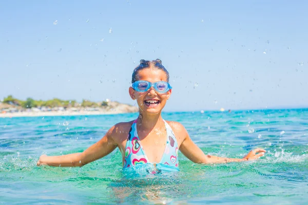 Ung flicka som leker i havet — Stockfoto