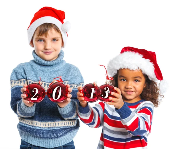 Niños en el sombrero de Santa sosteniendo una bola de Navidad — Foto de Stock