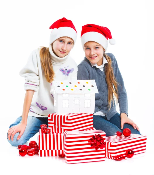 Ragazze felici in cappello di Babbo Natale con confezione regalo — Foto Stock