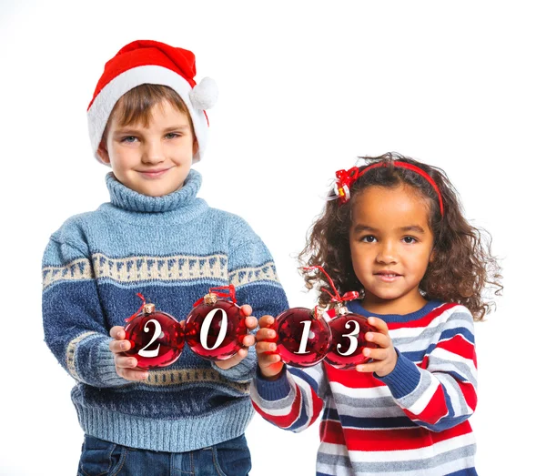 Niños en el sombrero de Santa sosteniendo una bola de Navidad —  Fotos de Stock