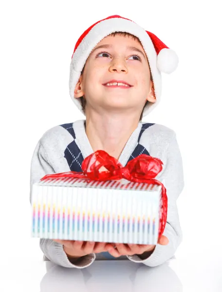 Petit garçon dans le chapeau du Père Noël avec boîte cadeau — Photo