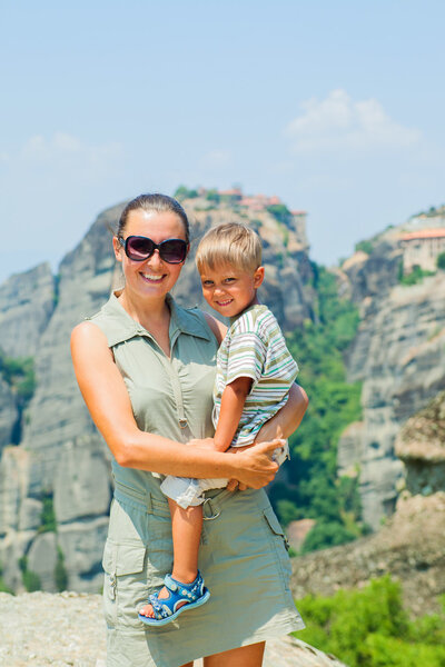 Мать и сын смотрят на город Каламбака с высоты птичьего полета. Вертикальный вид. Метеора, Греция
.