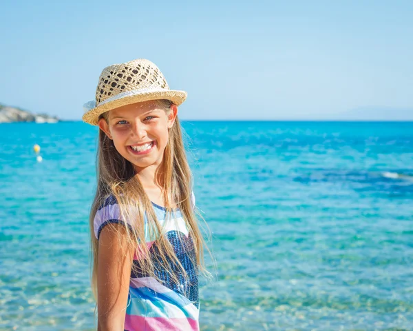 Söt flicka i hatt på stranden — Stockfoto