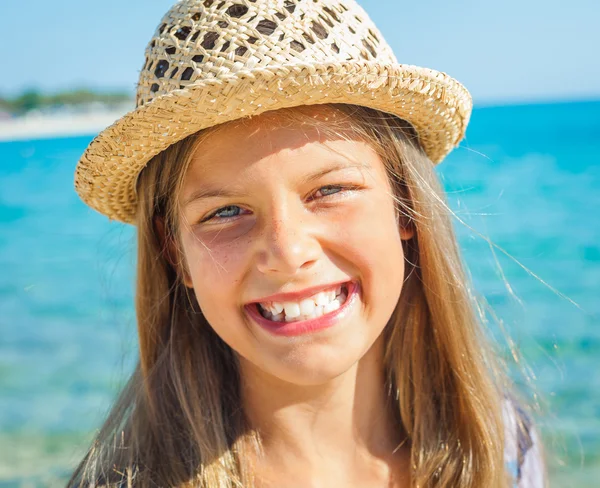 Söt flicka i hatt på stranden — Stockfoto