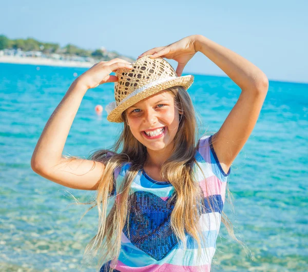 Nettes Mädchen mit Hut am Strand — Stockfoto