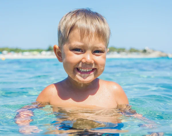 Portrait of young boy swimming in the transparent sea — Stock Photo, Image