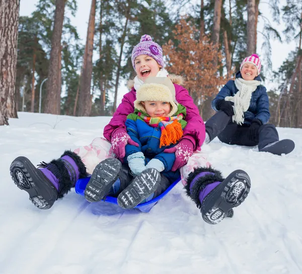 Dos niños con la madre es trineo en invierno-paisaje. Concéntrate en el chico . —  Fotos de Stock