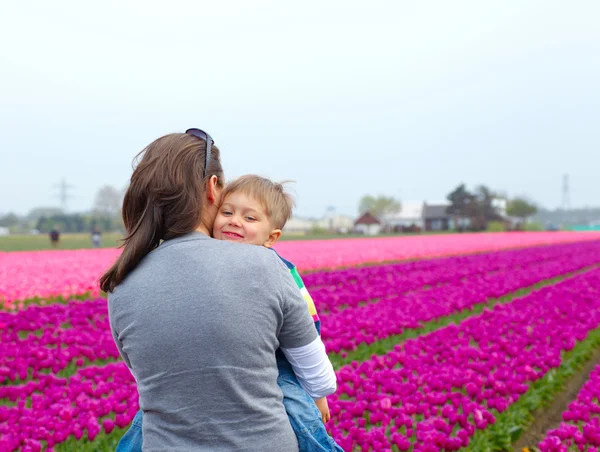 Хлопчик з матір'ю на полі тюльпанів — стокове фото