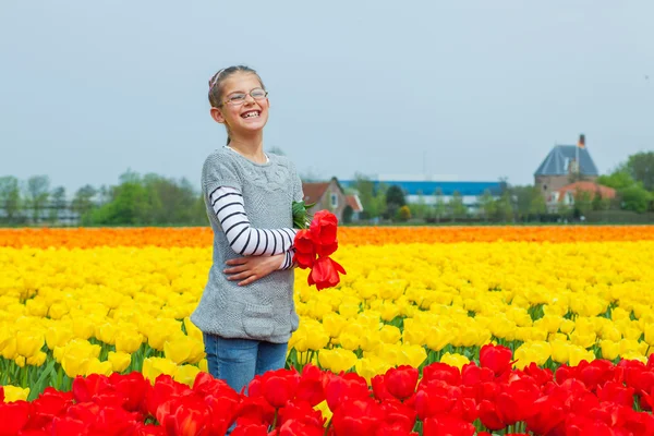 Glad tjej i tulpaner — Stockfoto