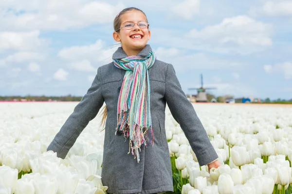 Счастливая девочка в тюльпанах — стоковое фото