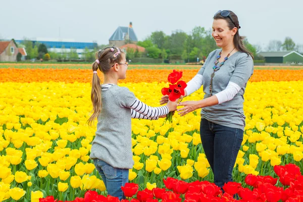 Menina com a mãe no campo de tulipas — Fotografia de Stock