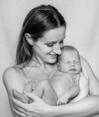 Yeni doğmuş bir bebek tutan anne