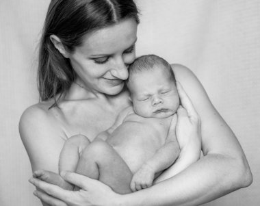 Yeni doğmuş bir bebek tutan anne