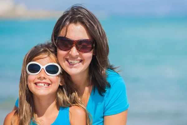 Mother and her daughter in sunglasses on beach — Stock Photo, Image