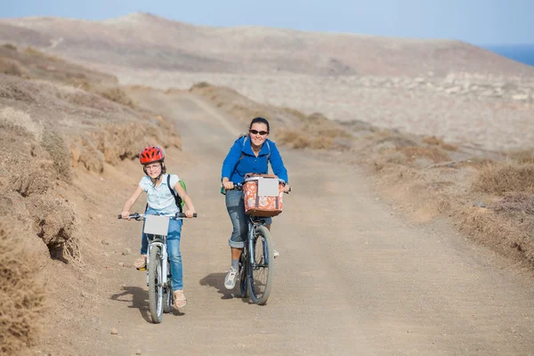 Flicka med sin mamma på cyklar — Stockfoto