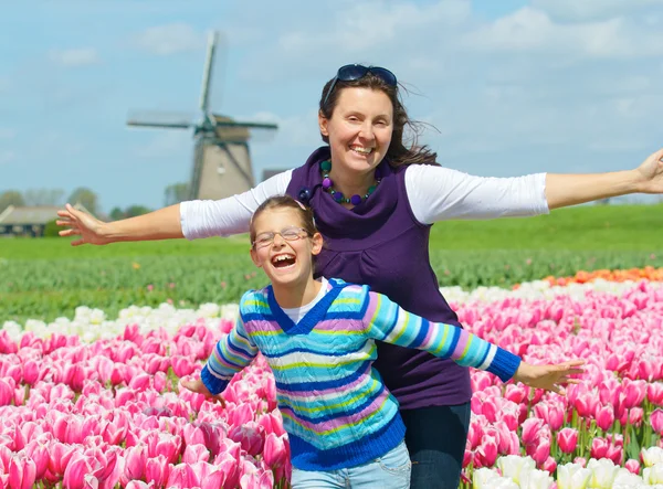 Jongen met moeder in het veld tulpen — Stockfoto