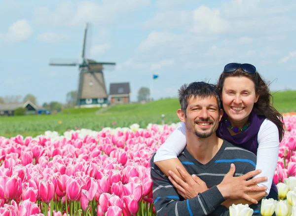 Pareja joven en el campo de tulipanes — Foto de Stock