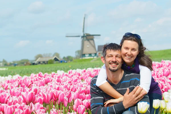 Pareja joven en el campo de tulipanes — Foto de Stock