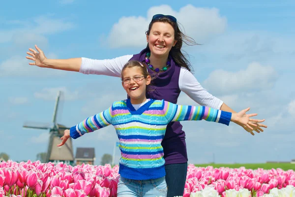 Jongen met moeder in het veld tulpen — Stockfoto