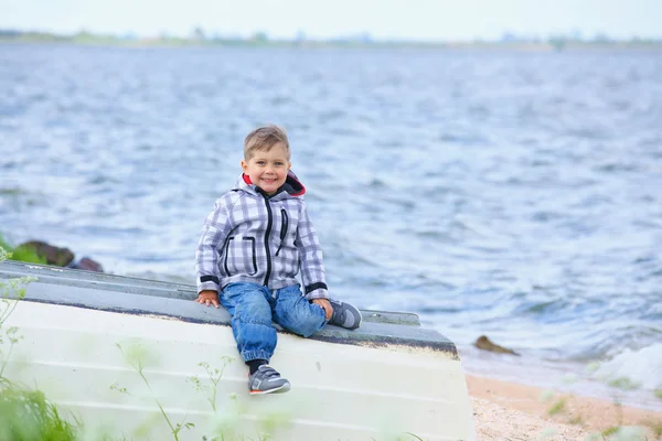 Schattige kleine jongen zittend op de boot — Stockfoto