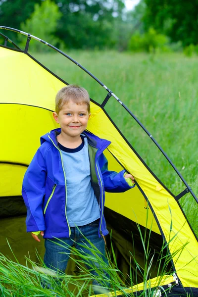 young boy camping with tent