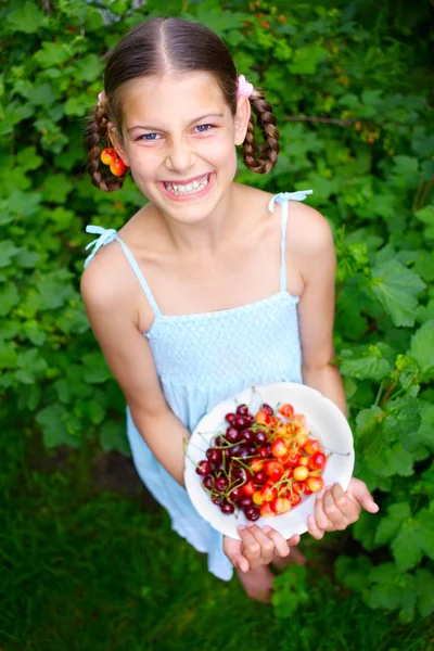 Mooie lachende meisje kersen eten in tuin — Stockfoto