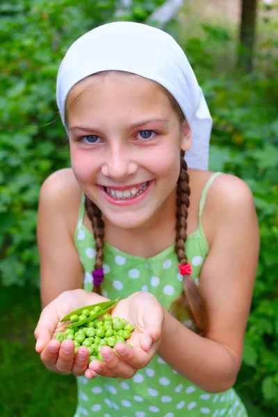 Портрет красивой девушки с зеленым горошком в саду — стоковое фото