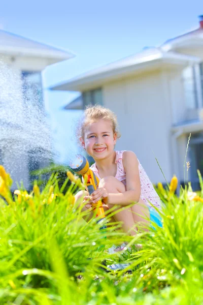 Pequena menina regando flores — Fotografia de Stock