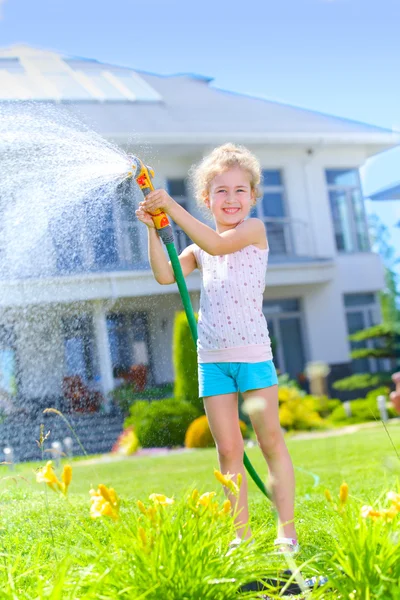 Little girl watering flowers — Stock Photo, Image