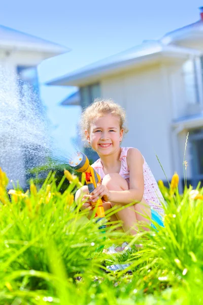 Little girl watering flowers — Stock Photo, Image