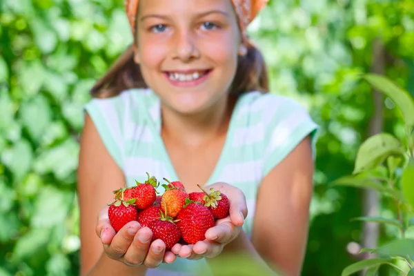 Молодая девушка держит в руках органические натуральные здоровые продукты питания - клубнику. Вертикальный вид — стоковое фото
