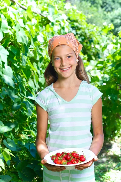 Νεαρή κοπέλα που κρατά πλάκα με οργανικά φυσικό υγιεινά προϊόντα - φράουλες. κατακόρυφη προβολή — Φωτογραφία Αρχείου
