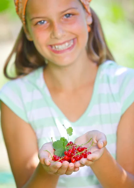 Jong meisje houden in de hand biologische natuurlijke gezonde voeding produceren - rode bessen. focus op de rode bessen. verticale weergave — Stockfoto
