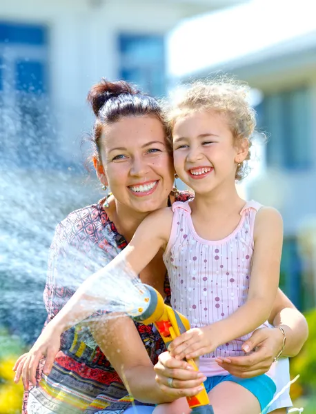 Liten flicka vattning blommor — Stockfoto