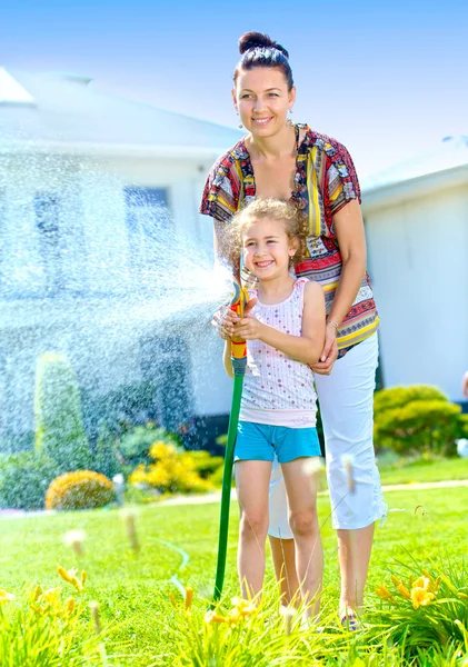 Meisje water geven bloemen — Stockfoto