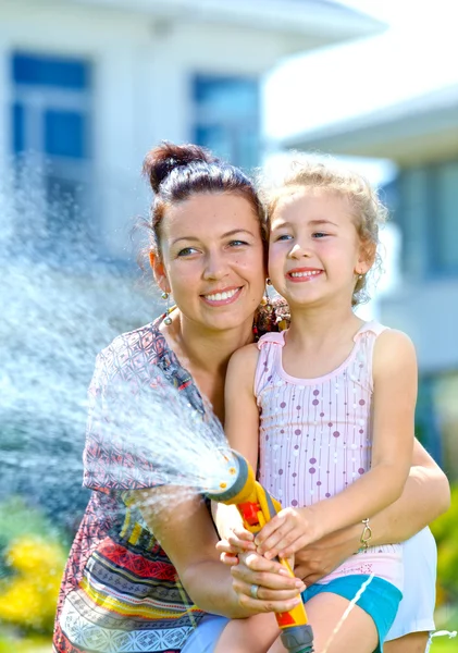 Meisje water geven bloemen — Stockfoto