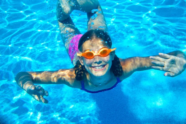 Roztomilá dívka, plavání pod vodou a s úsměvem — Stock fotografie