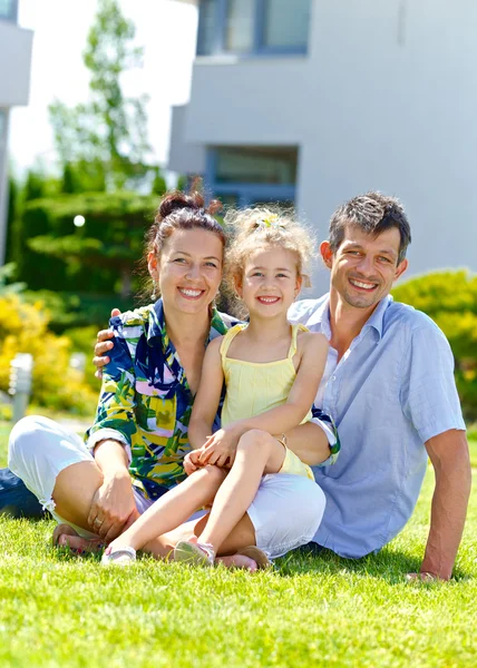 Šťastná rodina na trávníku před jeho nové chatě — Stock fotografie