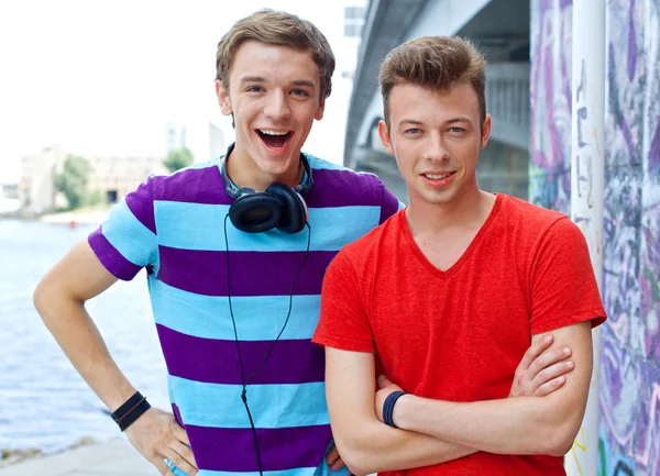 Portrait de heureux deux adolescents garçons par mur peint regardant la caméra — Photo