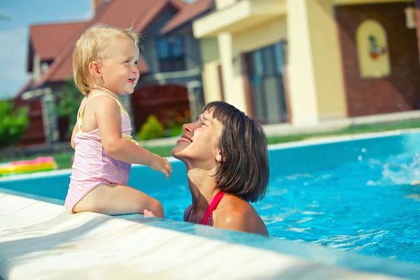 Sommerferien. hübsches kleines Mädchen mit ihrer Mutter im Schwimmbad im Freien — Stockfoto